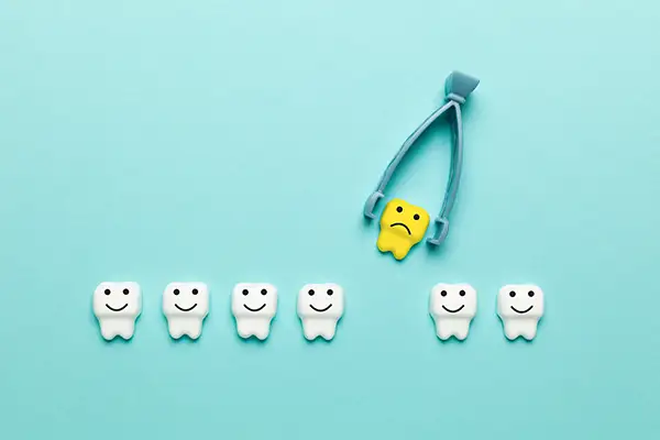 A sad tooth being pulled out of a row of happy teeth at Osborne Dentistry in Lebanon, OR A sad tooth being pulled out of a row of happy teeth at Osborne Dentistry in Lebanon, OR